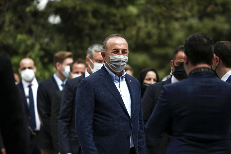 Turkish Foreign Minister Mevlut Cavusoglu, center, leaves a muslim cemetery at Komotini town, in northeastern Greece, Sunday, May 30, 2021. Greece's prime minister said Friday his country is seeking improved ties with neighbor and longtime foe Turkey, but that the onus is on Turkey to refrain from what he called "provocations, illegal actions and aggressive rhetoric." (AP Photo/Giannis Papanikos)