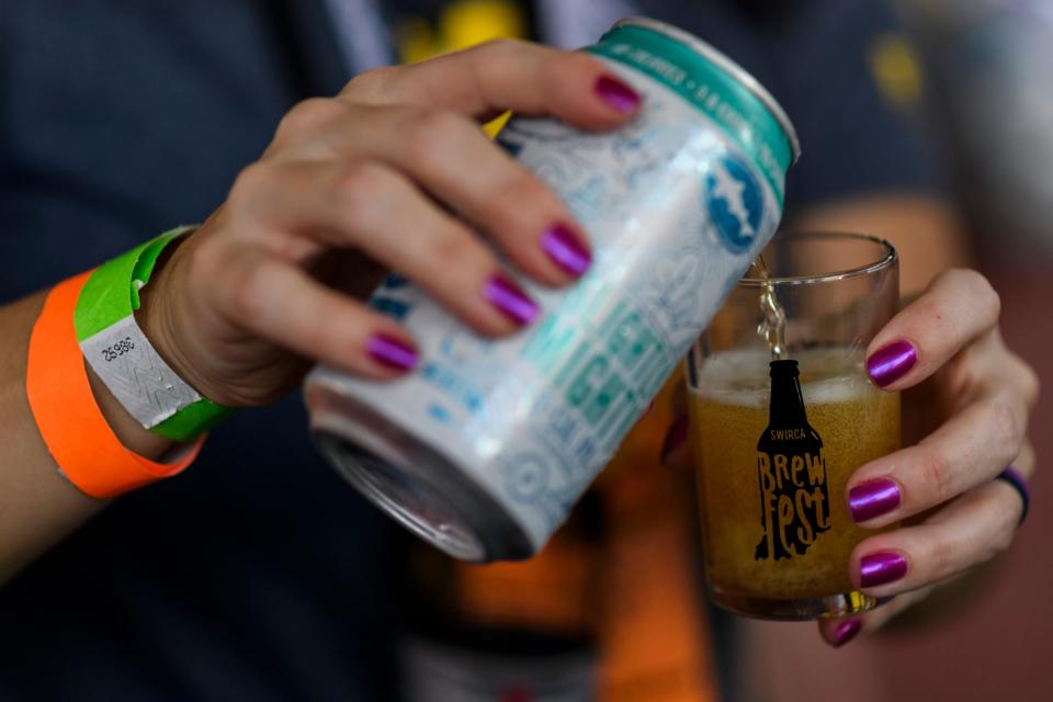 Gina Downs serves up a Slightly Mighty Lo-Cal India Pale Ale at the Dogfish Head Craft Brewery tent during the 16th annual SWIRCA Brewfest at Bosse Field in Evansville, Ind., Saturday, Sept. 28, 2019.