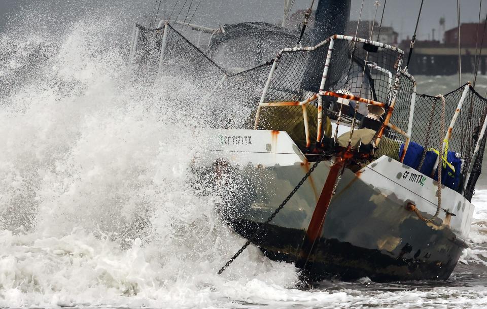 A wave hits a boat that washed ashore in Santa Barbara as a powerful atmospheric river, the second in less than a week, hit California on Feb. 4, 2024.