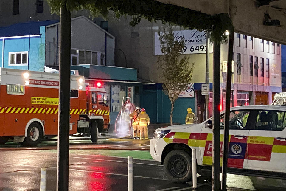 Firefighters stand outside a fire at a hostel in central Wellington, New Zealand, Tuesday, May 16, 2023. Several people were killed after a fire broke out overnight at the four-story building. (Nick James/NZ Herald via AP)