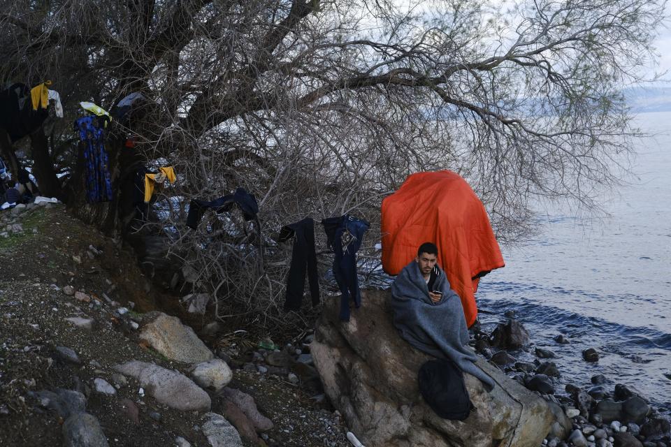 A migrant who arrived yesterday to Greece from Turkey tries to warm himself at the village of Skala Sikaminias, on the Greek island of Lesbos on Friday, March 6, 2020. Thousands of refugees and other asylum-seekers have tried to enter Greece from the land and sea in the week since Turkey declared its previously guarded gateways to Europe open. (AP Photo/Alexandros Michailidis)