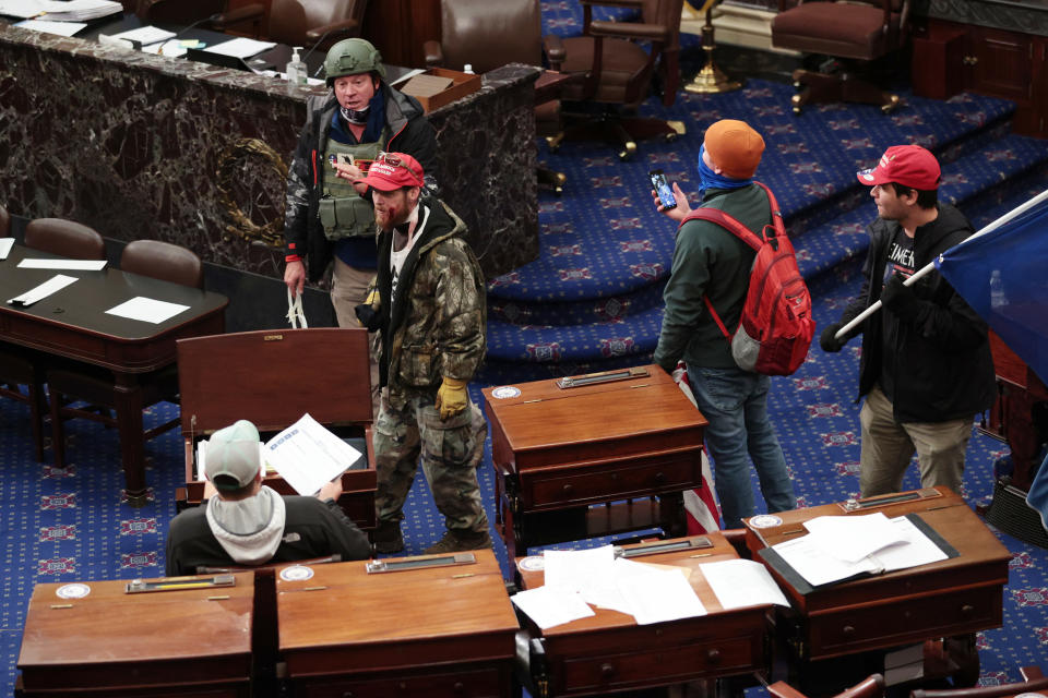 Larry Rendall Brock, back, wearing a combat helmet, is seen after entering the Senate Chamber during the Jan. 6 Capitol riot. He was identified to the FBI by his ex-wife of 18 years. (Photo: Win McNamee/Getty Images)
