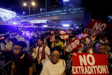 Demonstrators hold signs during a protest to demand authorities scrap a proposed extradition bill with China, in Hong Kong