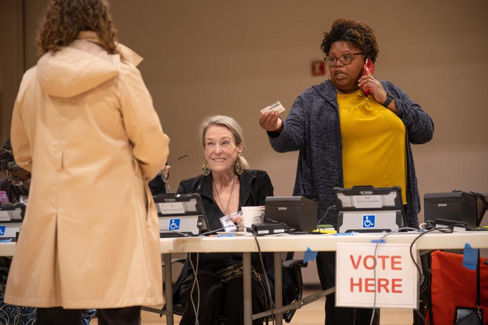 Melinda Newphr, precinct registrar, center, and India Scruggs, precinct officer, help a voter at the Belmont Sport Science Center 18-3 in Nashville, Tenn., Tuesday, March 5, 2024. The precinct saw a steady stream of voters throughout the day.