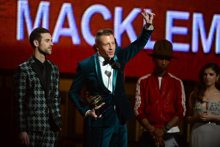 Winners for Best New Artist Macklemore (C) and Ryan Lewis accept their trophy during the 56th Grammy Awards at the Staples Center in Los Angeles, California, January 26, 2014