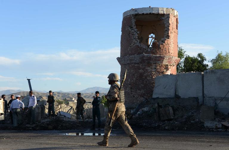 Afghan police and security inspect the site of a suicide attack targeting a police headquarters in Jalalabad, the capital of eastern Nangarhar province, on June 1, 2015