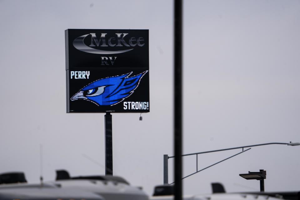 A sign reading "Perry Strong" is displayed near the edge of town following a shooting at Perry High School on Thursday.