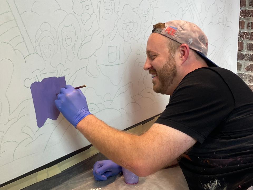Erik Lundorf works on a mural at the entrance to the Indiana Farm Bureau Fall Creek Pavilion at the Indiana State Fairgrounds. The facility was unveiled July 20, 2023.