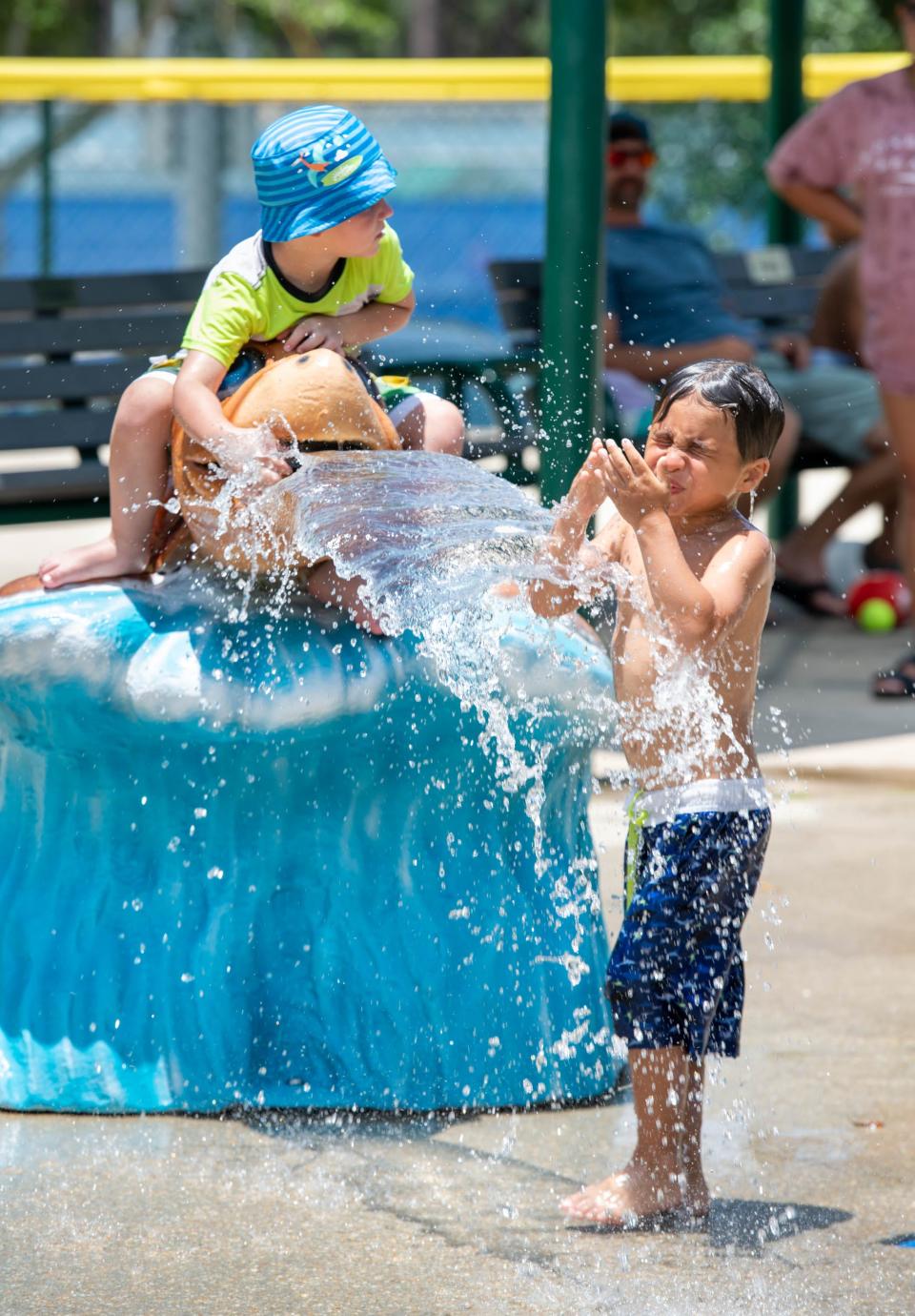 From left, Joseph White, 3, Maddox Gardner, 10, and Benjamin Gardner, 5, cool off on the hot day at the Dolphin Island Splash Pad in Gulf Breeze on Monday, June 26, 2023.