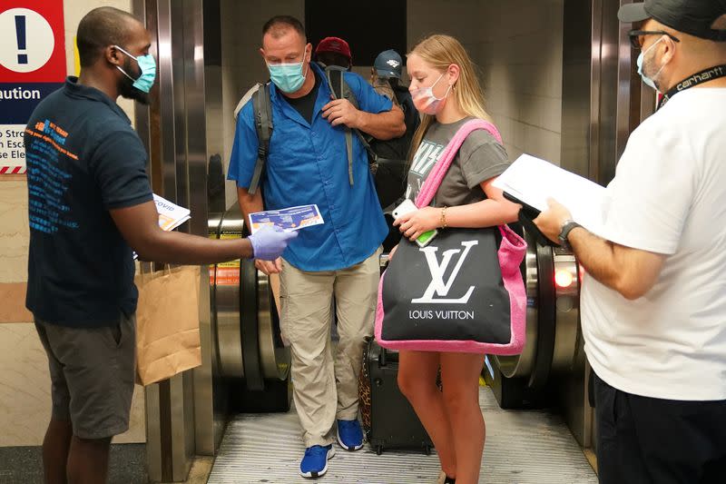 Passengers on a train from Florida stop and register with officials at Penn Station during an effort to screen out-of-state travellers and enforce the state's 14-day coronavirus disease (COVID-19) quarantine, in New York City