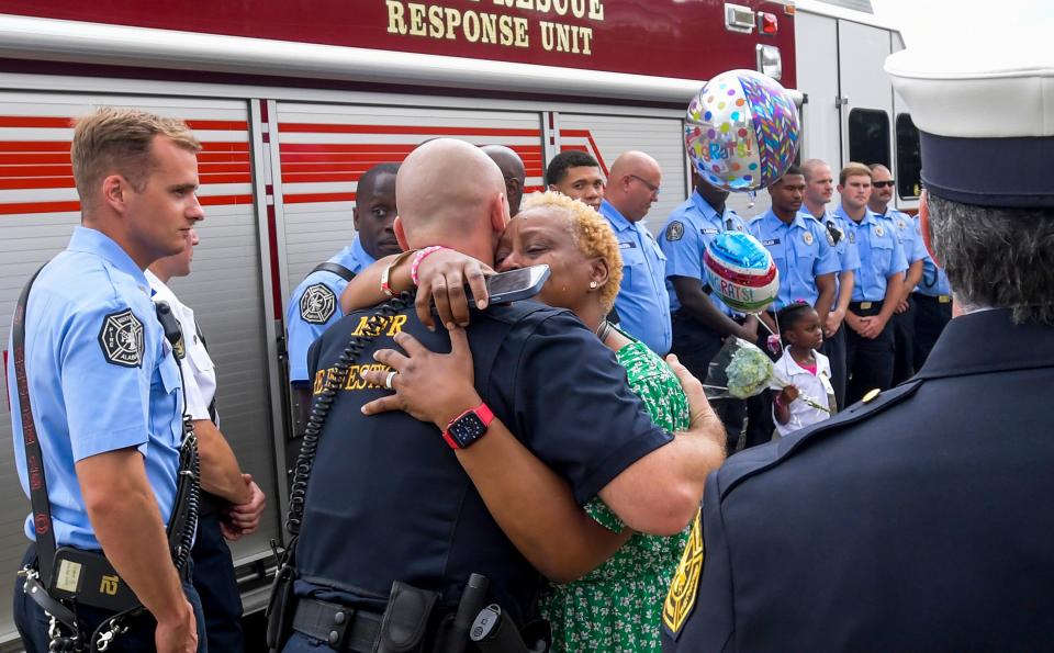 Chalita Hartman-Thornton, mother of injured firefighter Deandre Hartman, hugs the firefighters who came to Forest Avenue Academic Magnet School to honor her granddaughter, student Dynasti Hartman, in Montgomery, Alabama, on Monday, May 22, 2023. Deandre Hartman was injured in a fire on May 14 and is being treated in the UAB Hospital Burn abd Trauma ICU.