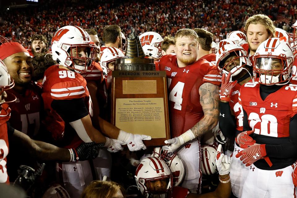 UW's C.J. Goetz (98) and Michael Furtney hold the Freedom Trophy after a overtime win against Nebraska on Saturday. Up next are the rival Minnesota Golden Gophers and the battle for Paul Bunyan's Axe.