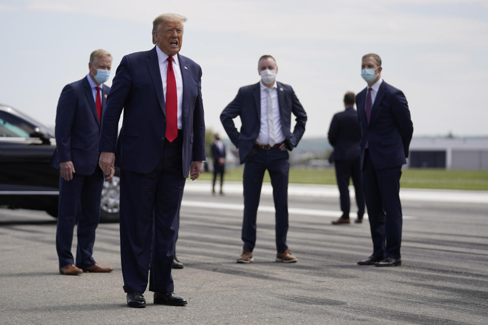 Donald Trump fotografiado sin tapabocas al llegar al aeropuerto de Allentown, Pensilvania, el 14 de mayo del 2020. Todos sus custodios tienen barbijos. (AP Photo/Evan Vucci, File)