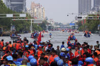 Rescuers use boats to evacuate people from a flooded area in Weihui in central China's Henan Province, Monday, July 26, 2021. Residents laid flowers on Tuesday at the entrance of a subway station where more than a dozen people died after a record-breaking downpour flooded large swaths of Henan province in central China. (Chinatopix via AP)