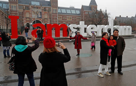 FILE PHOTO: Tourists pose for photos outside the Rijksmuseum in central Amsterdam, Netherlands, December 1, 2017. REUTERS/Yves Herman/File Photo