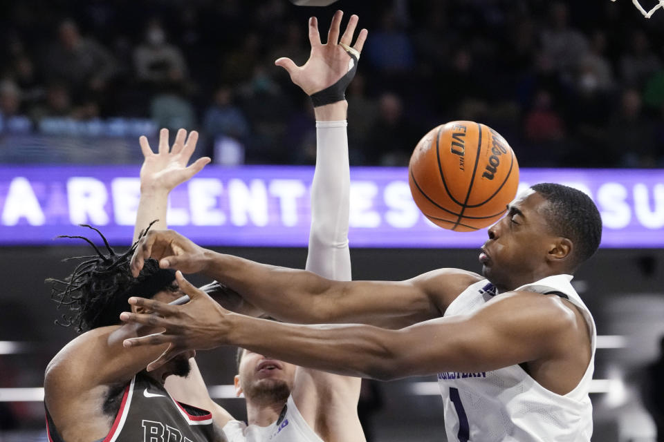 Brown forward Kalu Anya, left, Northwestern guard Chase Audige, right, and forward Robbie Beran battle for a loose ball during the first half of an NCAA college basketball game in Evanston, Ill., Thursday, Dec. 29, 2022. (AP Photo/Nam Y. Huh)