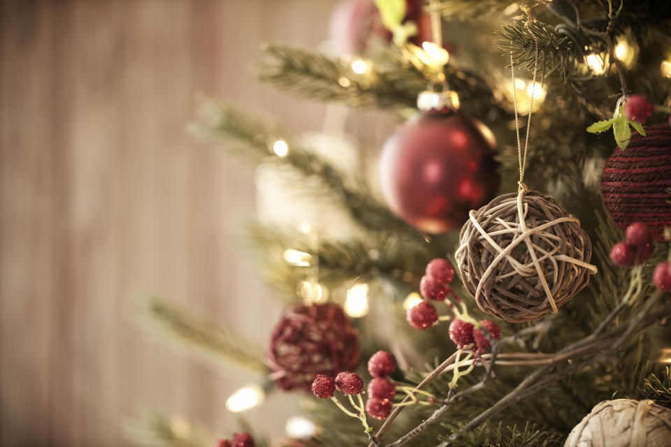 Christmas tree with eco friendly decorations, ornaments and gifts on an old wood background. (Getty Images)