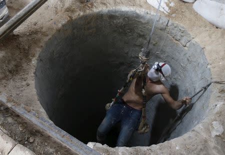 A Palestinian worker is lowered on a rope into a smuggling tunnel, that was flooded by Egyptian security forces, beneath the border between Egypt and southern Gaza Strip November 2, 2015. REUTERS/Mohammed Salem