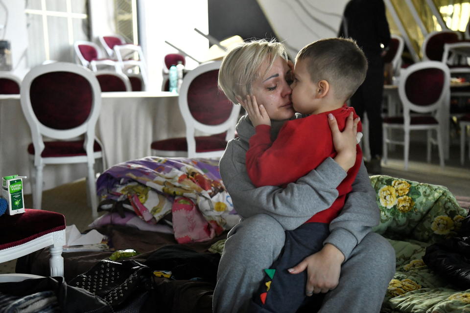 Egor, 5, held in his mother's arms in a temporary shelter, kisses her. 