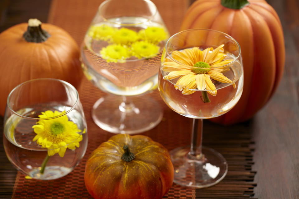 Table centerpiece ideas: a trio water-filled glasses with fall flowers floating in water. An easy water feature for a Thanksgiving tabletop!