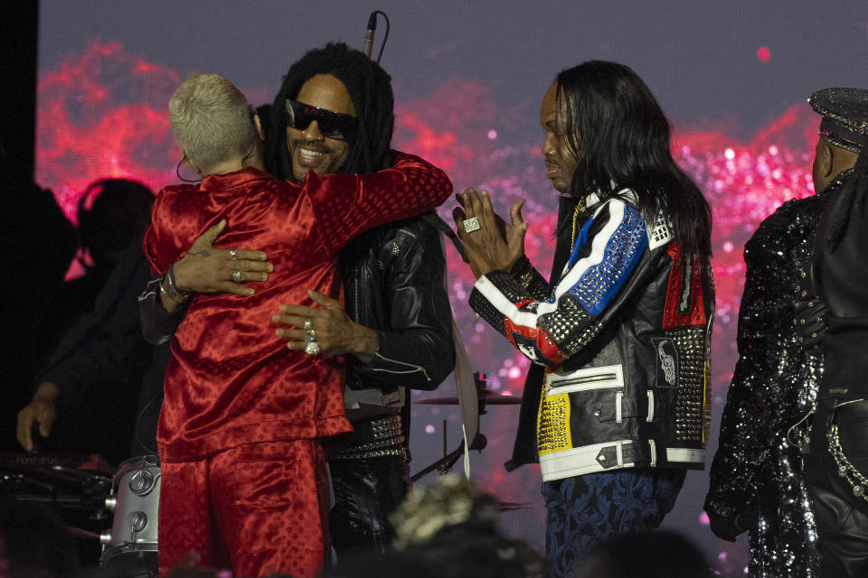 Andrew Watt, left, hugs four-time Grammy-winning artist Lenny Kravitz, and Verdine White, right, after Kravitz was honored with the Recording Academy Global Impact Award at the third annual Recording Academy Honors Presented by The Black Music Collective in Los Angeles on Thursday, Feb. 1, 2024. (AP Photo/Damian Dovarganes)