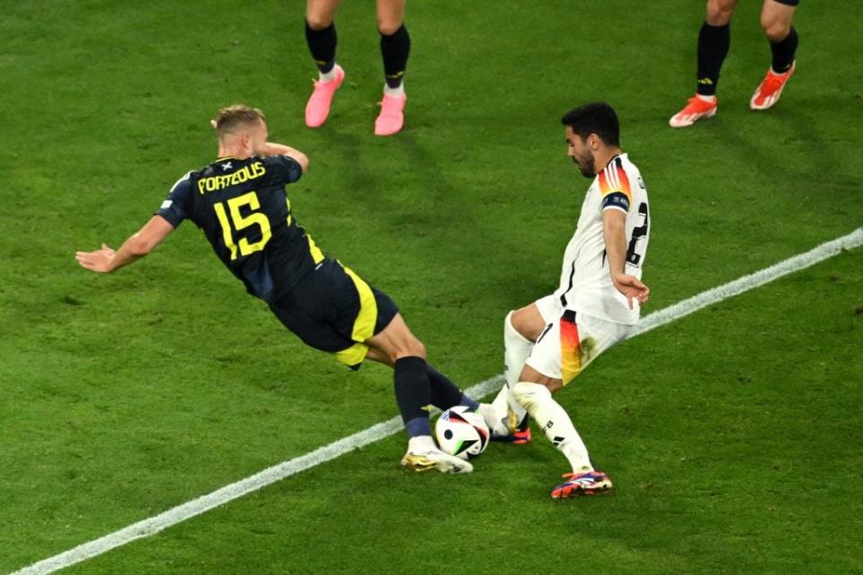 Ilkay Gundogan received a heavy challenge from Scotland’s Ryan Porteous. (Photo by Clive Mason/Getty Images)