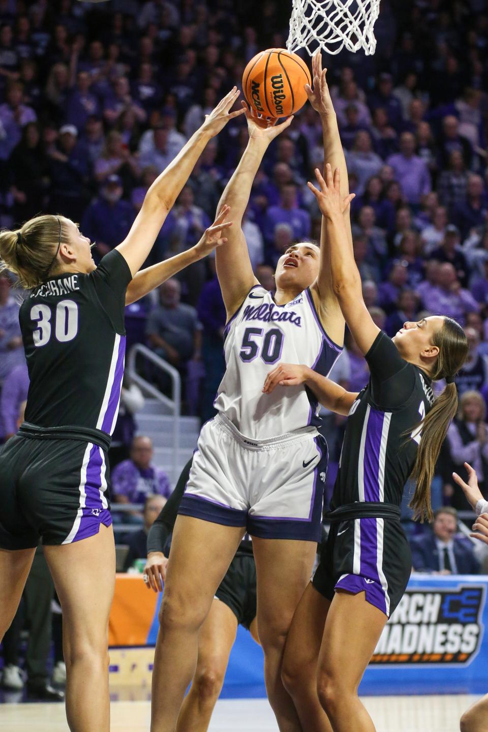 Kansas State center Ayoka Lee (50) puts up a shot against Portland's Lucy Cochrane (30) and Maisie Burnham (24) during Friday's first-round NCAA Tournament game at Bramlage Coliseum in Manhattan.