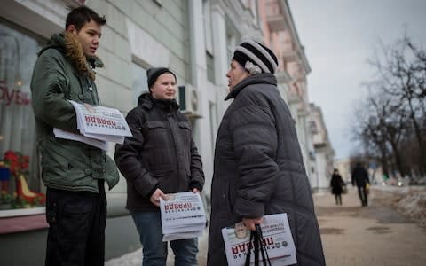 Daniil Zolin and Yaroslav Putrov speak with pensioner Nina Alexandrovna while distributing Navalny leaflets - Credit: Dmitri Beliakov/For The Telegraph