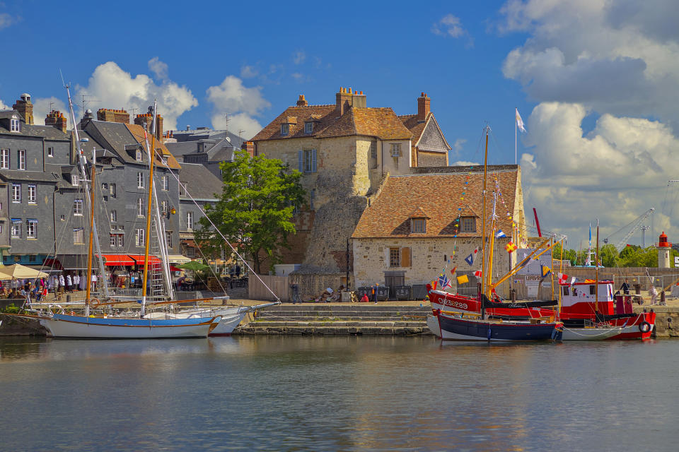 Harbor view with boats docked near old stone buildings under a cloudy sky