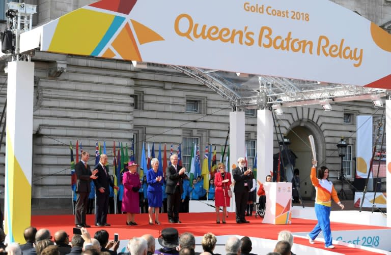 Retired cysclist Anna Meares (R) from Australia carries the baton after receiving it from Britain's Queen Elizabeth during the launch of the Queen's baton relay for the 2018 Commonwealth Games at Buckingham Palace in London on March 13, 2017