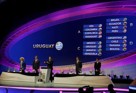 Feb 21, 2016; New York, NY, USA; Jurgen Mainka, CONCACAF’s Deputy General Secretary holds up a card assigning Uruguay to group C as the final team given its draw during the 2016 Copa America Centenario draw event at Hammerstein Ballroom. Former soccer stars, Carlos Valderrama, Jorge Campos, Alexi Lalas, Mario Kempes join Mainka on stage. Mandatory Credit: Adam Hunger-USA TODAY Sports