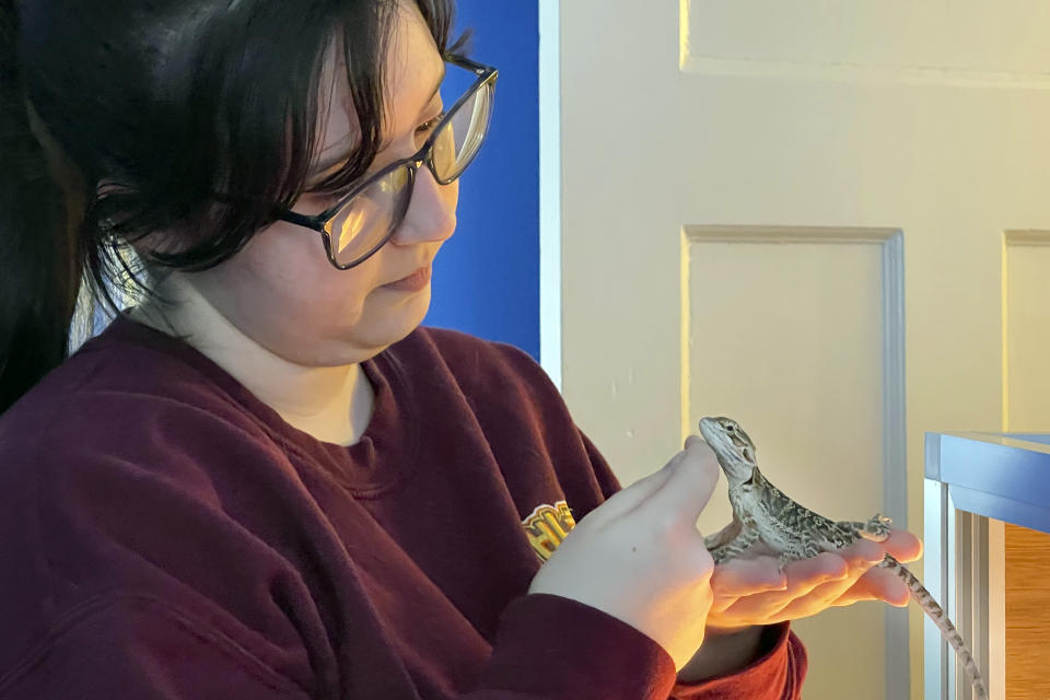 Angelina Mistretta, a 16-year-old junior at City Honors High School holds her pet bearded dragon Kaida, at home in Buffalo, N.Y., Feb. 17, 2021. When in-person school stopped, the expectations that come with attending the school did not. On the 16-year-old junior’s schedule this year are International Baccalaureate literature, AP history, Algebra 2, an IB French class and an IB biology class. (AP Photo/Carolyn Thompson)