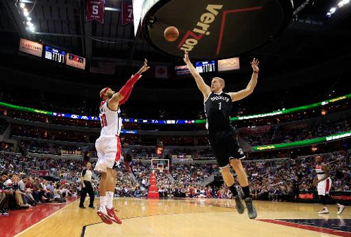 Drew Gooden, #90 de los Washington Wizards, lanza desde fuera de la llave frente al intento defensivo de Mason Plumlee, #1 de los Brooklyn Nets, durante la segunda mitad del partido de la liga NBA en el Verizon Center, el 15 de marzo de 2014, en Washington, DC. (GETTY IMAGES NORTH AMERICA/AFP | Rob Carr)