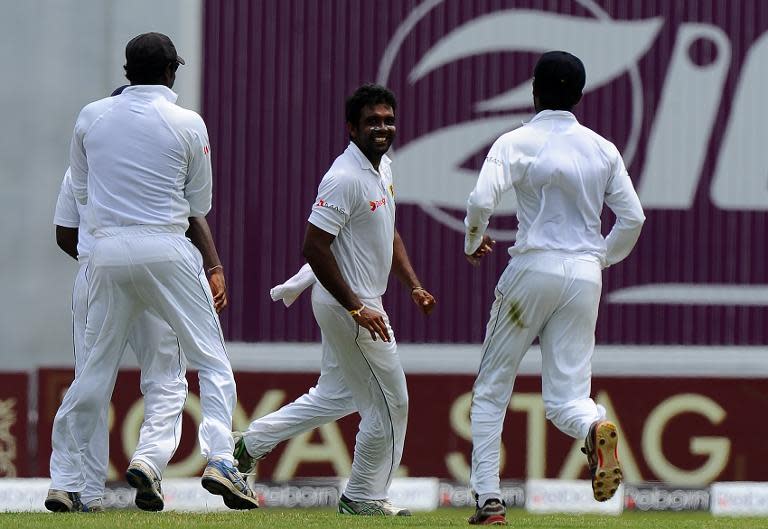 Dilruwan Perera (centre) celebrates with teammates after dismissing Quinton de Kock during the third day of the second Test in Colombo on July 26, 2014