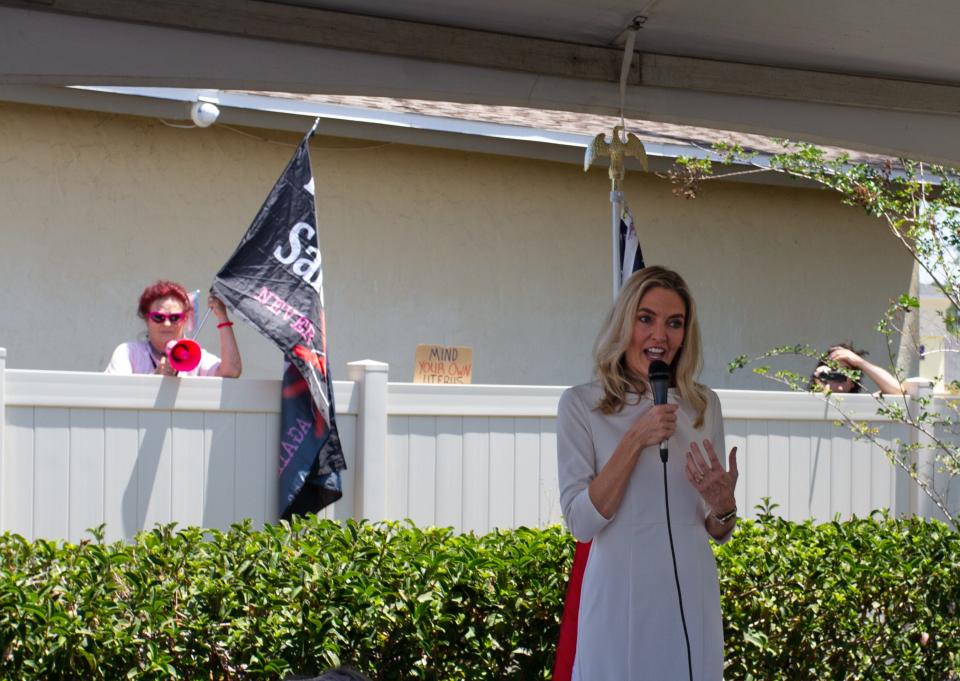 Bonnie Patterson James, left, can be seen protesting as Florida Rep. Jennifer Canady, R-Lakeland, speaks Tuesday after during a groundbreaking ceremony at the Options for Women property on South Florida Avenue. Patterson-James was arrested Thursday on a charge that she threw a pair of rolled-up women's underwear that hit a Polk County Sheriff's Office deputy.