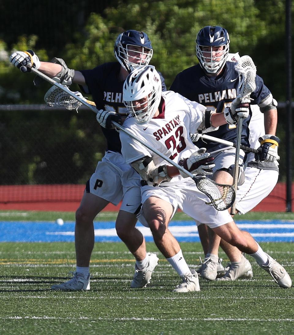 Pelham's Alessio Johnson (34) and Nick Loria (27) put pressure on Burnt Hills-Ballston Lake Shane McClernan (23) during the boys lacrosse Class C regional final at Shaker High School in Albany June 4, 2022.  Burnt Hills-Ballston Lake won the game.