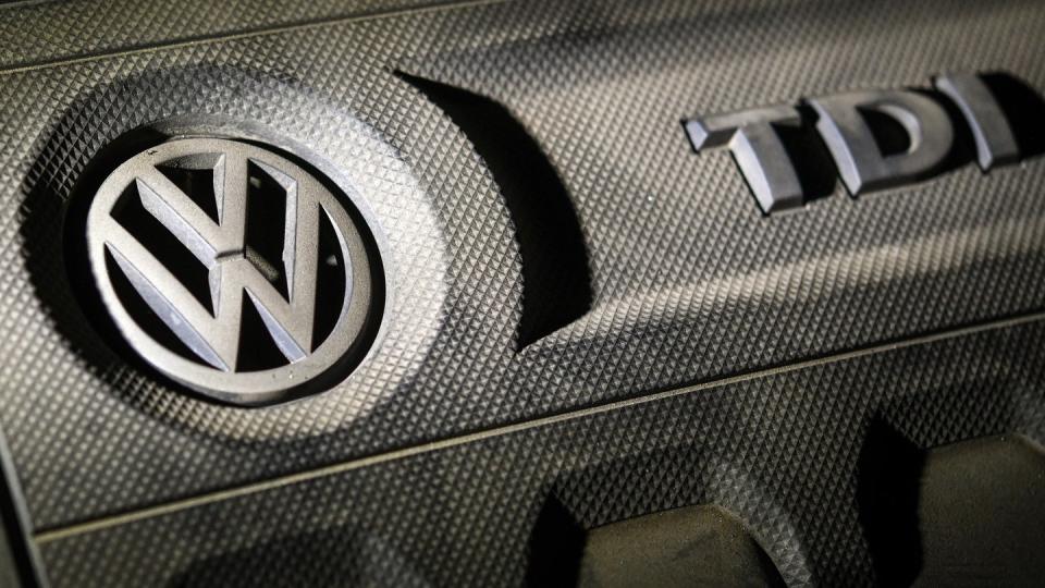 Das Logo von Volkswagen auf einer Motorabdeckung eines VW Golf 2,0 TDI. Foto: Patrick Pleul/zb/dpa