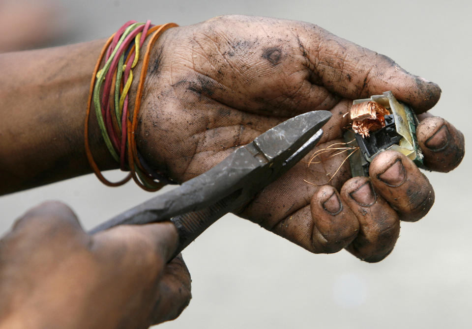 Ein junge entfernt Kupfer aus Elektromüll in Manila. (Bild: reuters)A boy recovers copper from discarded electronic waste, to be exchanged for money at nearby junkshops, along a road in Manila April 7, 2011. An e-waste recycling and reclamation company salvages gold and other precious metals like silver, copper and palladium from microprocessors of discarded electronic products like desktop computers, laptops, mobile phones and copying machines. About 4000 integrated circuits from discarded mobile phones can produce about 100 grams of gold. REUTERS/Cheryl Ravelo (PHILIPPINES - Tags: SOCIETY EMPLOYMENT BUSINESS ENVIRONMENT)