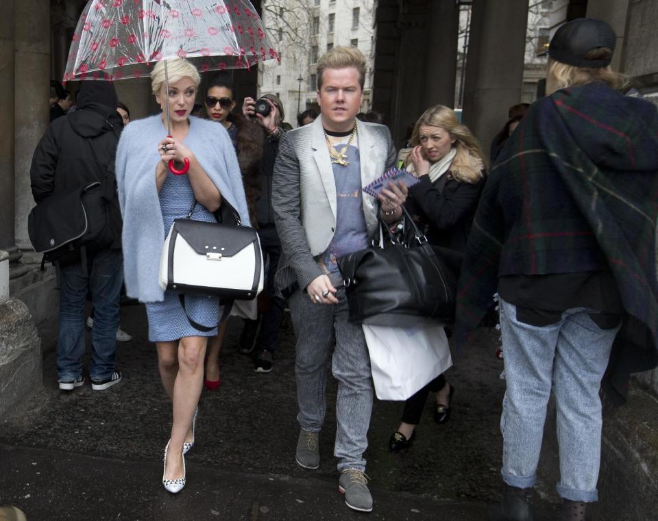 Actress Helen George arrives carrying an umbrella for the first day of London Fashion Week, in London, Friday, Feb. 14, 2014. (AP Photo/Alastair Grant)