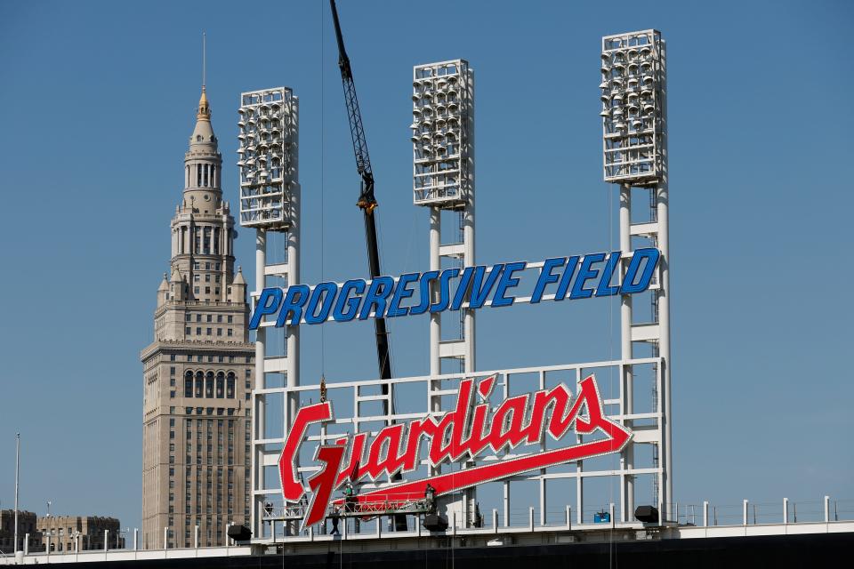 Workers finish installing the Cleveland Guardians sign above the scoreboard at Progressive Field on March 17, 2022, in Cleveland.