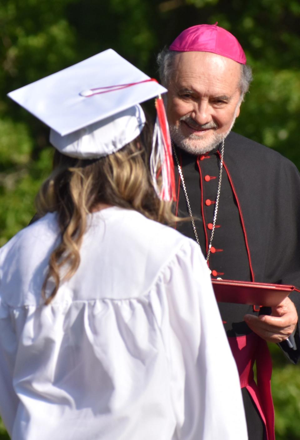 Diocese of Fall River Bishop Edgar M. da Cunha hands a diploma to Cadence Olivia Camara at the school's commencement ceremony on Wednesday, May 31, 2023.