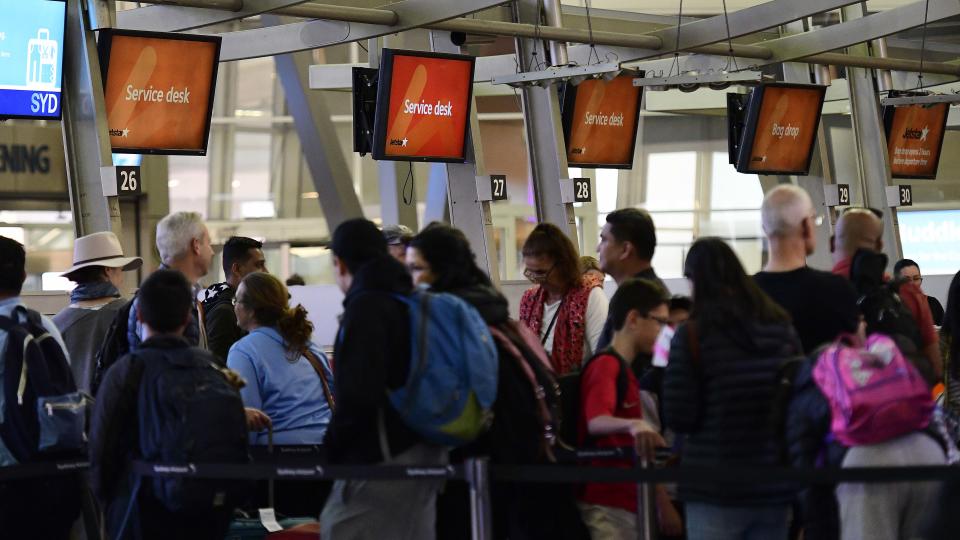 People are seen lining up at the Jetstar bag drop desks in the domestic departures terminal at Sydney Airport, Sydney, Saturday, July 13, 2019. Hundreds of flights in and out of Sydney airport have been delayed or cancelled due to the wild weather and winds currently battering the state. (AAP Image/Bianca De Marchi) NO ARCHIVING