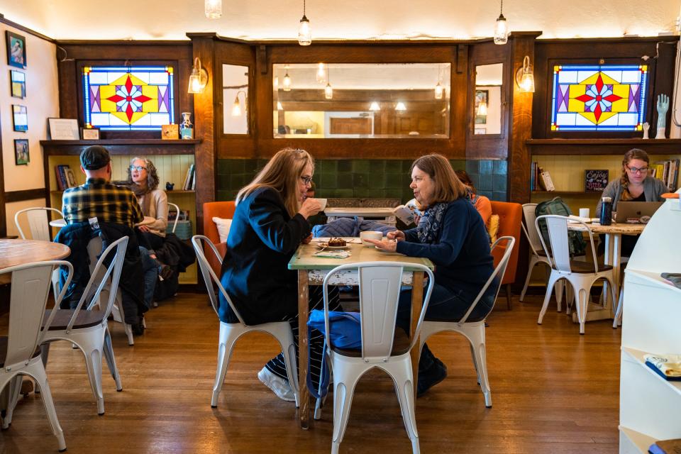 Karen Folger, center left, and Ellen Switzer drink coffee and eat bostocks at Little Bird Bakeshop on Wednesday, March 29, 2023, in Fort Collins. The bakery reopened in its new location at 613 S. College Avenue, which Canino's formerly occupied prior to its closing.