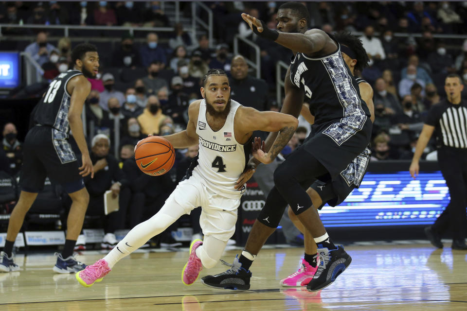 Providence's Jared Bynum (4) drives to the basket as Georgetown's Timothy Ighoefe (5) defends during the first half of an NCAA college basketball game Thursday, Jan. 20, 2022, in Providence, R.I. (AP Photo/Stew Milne)