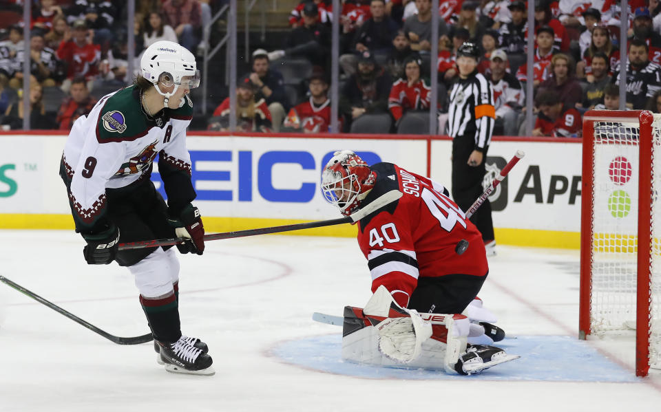 Arizona Coyotes right wing Clayton Keller (9) scores a goal against New Jersey Devils goaltender Akira Schmid (40) during the second period of an NHL hockey game, Saturday, Nov. 12, 2022, in Newark, N.J. (AP Photo/Noah K. Murray)