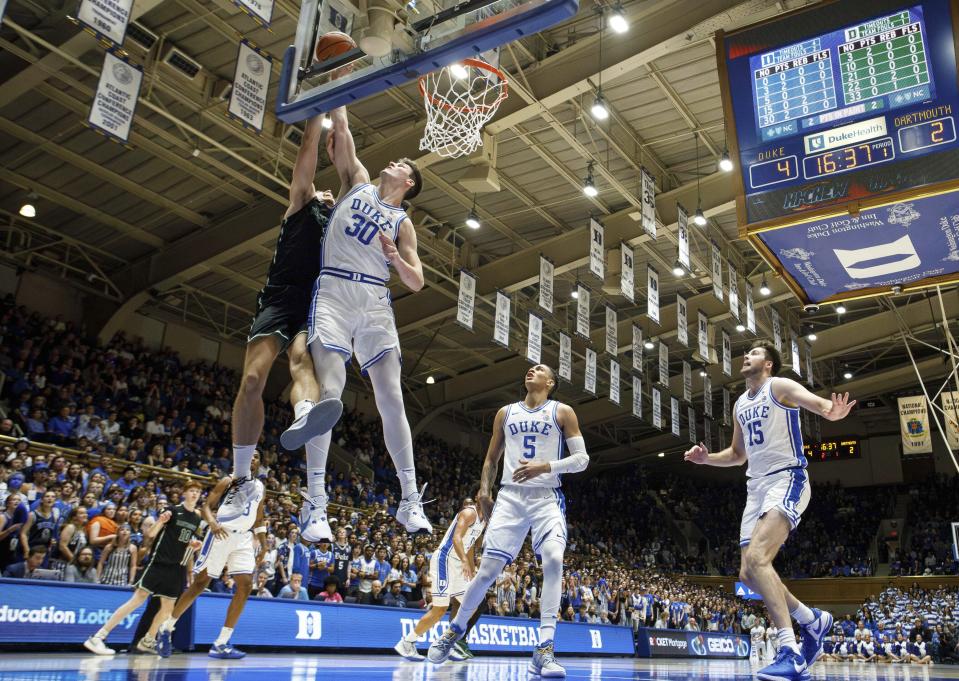 Duke's Kyle Filipowski (30) blocks the shot of Dartmouth's Dusan Neskovic, left, ahead of Duke's Tyrese Proctor (5) and Ryan Young (15) during the first half of an NCAA college basketball game in Durham, N.C., Monday, Nov. 6, 2023. (AP Photo/Ben McKeown)