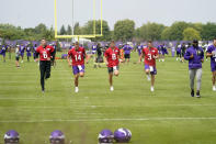 Minnesota Vikings quarterbacks Danny Etling (6), Nate Stanley (14), Kirk Cousins (8) and Jake Browning jog during the NFL football team's training camp, Thursday, Aug. 5, 2021, in Eagan, Minn. (AP Photo/Jim Mone)