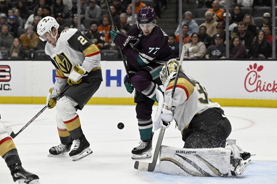 Vegas Golden Knights goaltender Logan Thompson, right, blocks a shot as Anaheim Ducks right wing Frank Vatrano, center, and Golden Knights defenseman Zach Whitecloud, left, look for the puck during the second period of an NHL hockey game in Anaheim, Calif., Wednesday, Dec. 27, 2023. (AP Photo/Alex Gallardo)