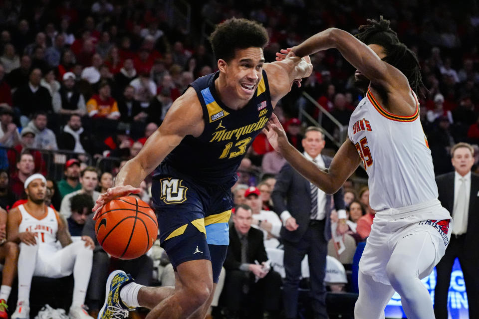 Marquette forward Oso Ighodaro (13) drives to the basket as St. John's forward Glenn Taylor Jr. (35) defends during the first half of an NCAA college basketball game in New York, Saturday, Jan. 20, 2024. (AP Photo/Peter K. Afriyie)