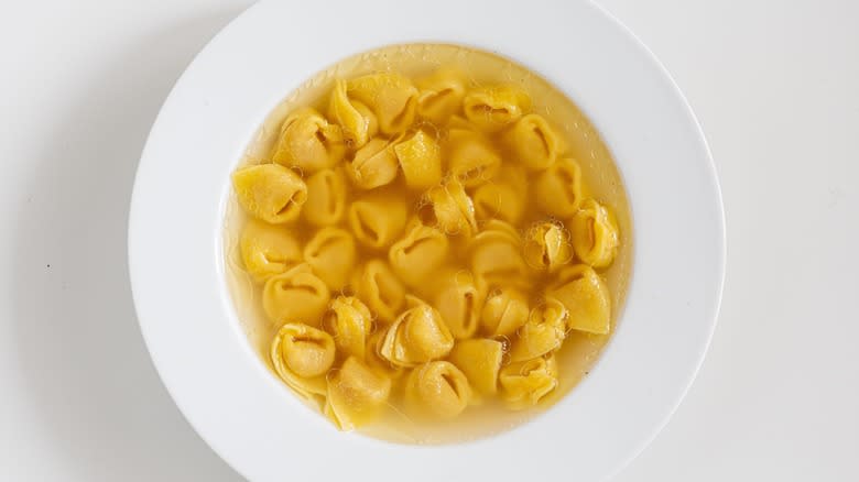 broth with tortellini in bowl